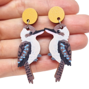 Kookaburra wooden earrings resting on woman's hand
