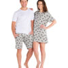 Woman stands with arm on a man's shoulder and man has hands in pockets, both smiling. Woman wears grey sleep dress with panda print and man wears a white tshirt and grey shorts with panda print