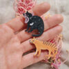 Tasmanian Devil and Tiger wooden brooch resting on woman's hand
