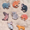 Rnage of wooden animal pins resting on soft linen material
