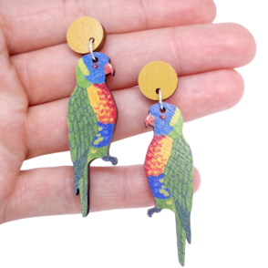 Rainbow Lorikeet wooden earrings resting on woman's hand
