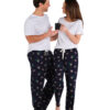Woman and man turned in to face each other smiling. Man and woman wear a white tshirt and navy blue sleep pants featuring a koala print