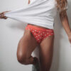 Woman pulling white bamboo tshirt to the side showing red bamboo underwear briefs